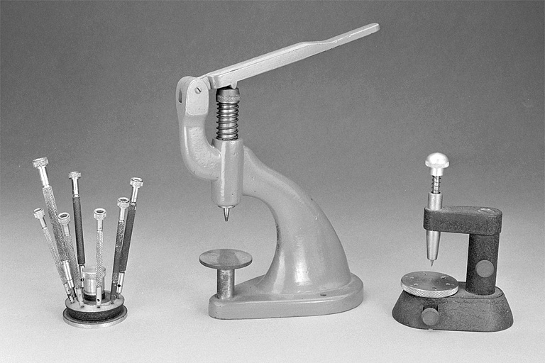 outils spécifiques aux métiers de l'horlogerie (2 potences à chasser, 7 tournevis et leur socle)
